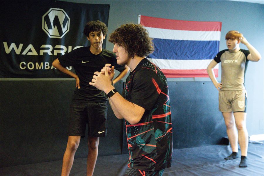 Warrior fighters ready to spar under the gym banner and Thai flag