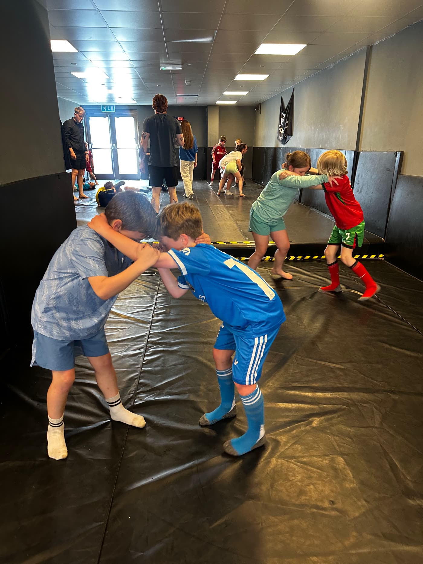 A kids class paired up on the mats at Warrior Combat Gym
