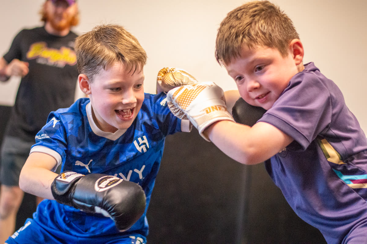 Two young Warriors sparring at the gym, both grinning